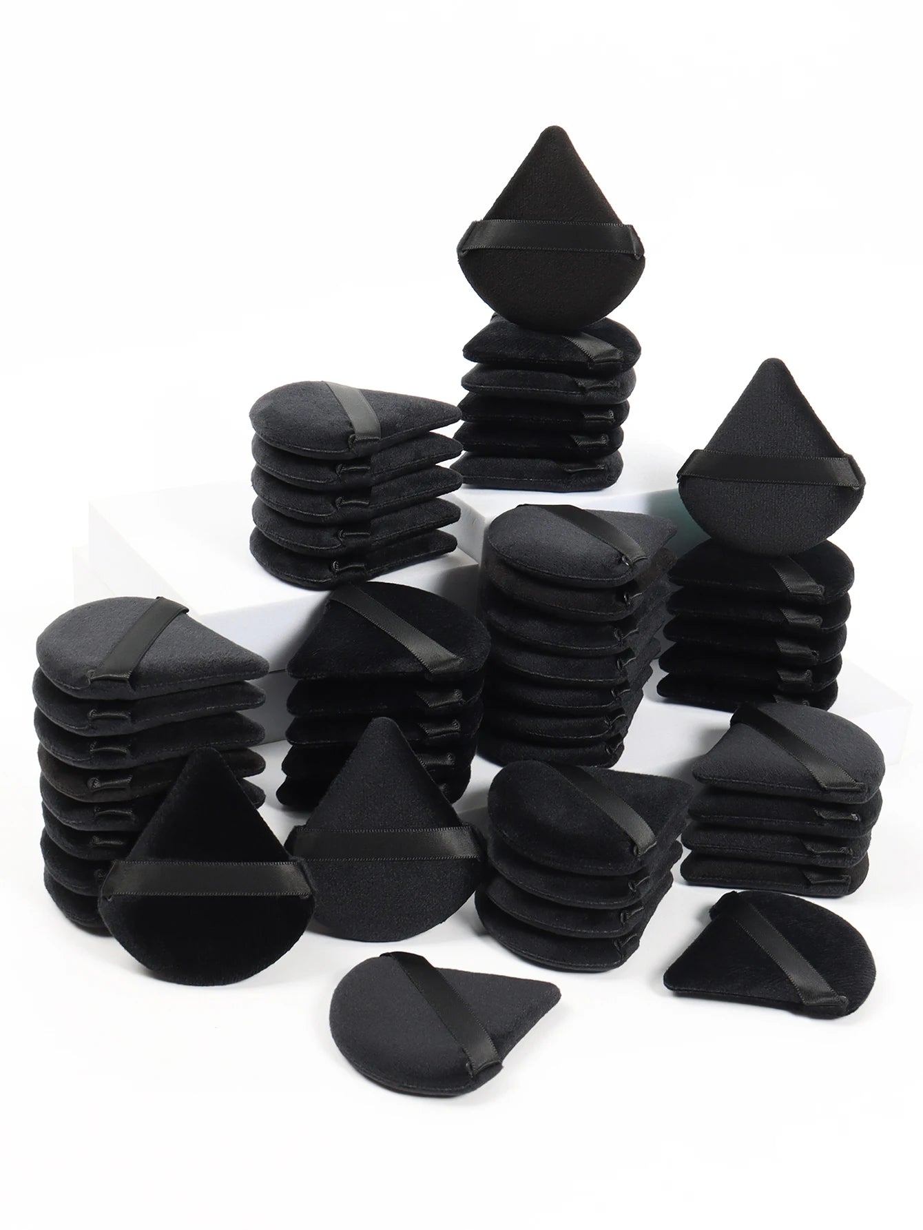 Black triangle-shaped powder puff from amzzonstore, soft velvet makeup sponge for foundation and cosmetic blending.