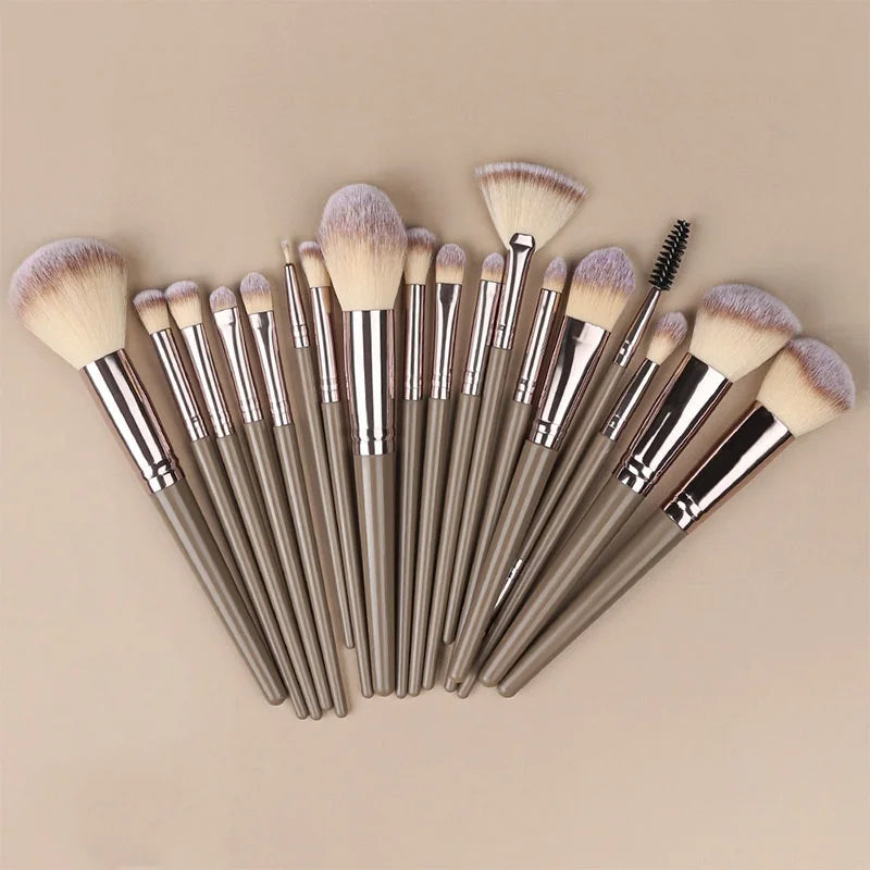 Set of professional makeup brushes including foundation, eyeshadow, concealer, blush, and kabuki brushes in soft, fluffy bristles.